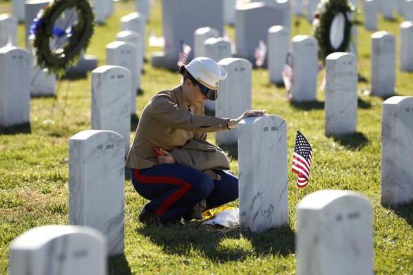 Đại úy Jill A.Leyden chạm tay vào nấm mộ của người bạn thân là Thiếu tá Megan M.McClung ở Nghĩa trang quốc gia Arlington trong ngày Cựu chiến binh 11/11/2010. McClung đã hi sinh trong cuộc hành quân giải phóng Iraq ngày 06/12/2006.